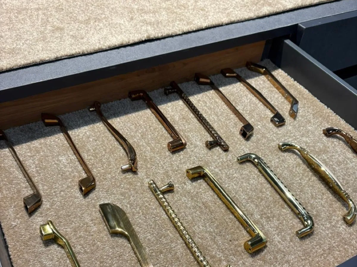 Tray of assorted cabinet handles in different shapes and metal finishes