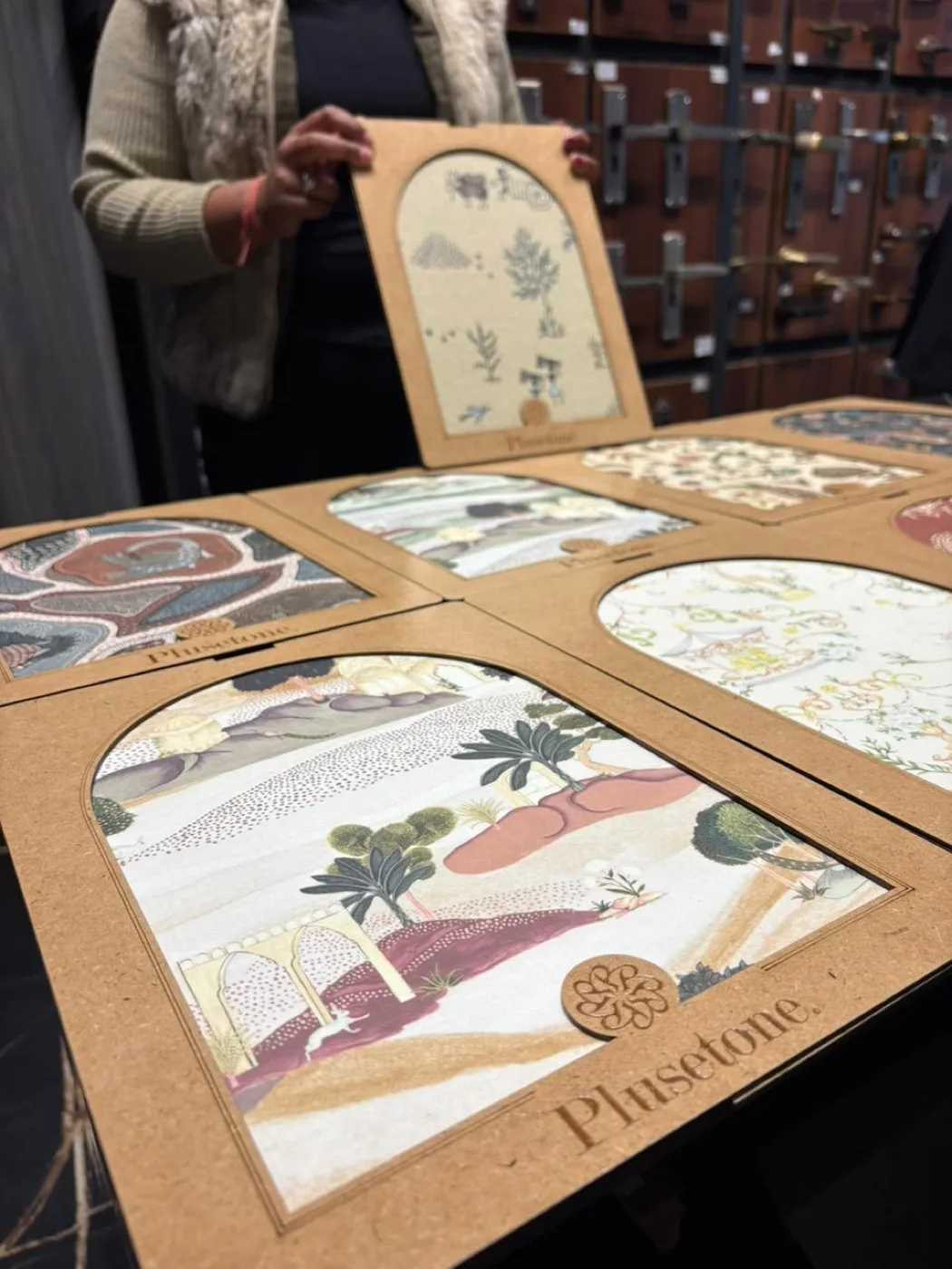 Arch-cut decorative laminate samples in printed Indian patterns, laid out on a showroom counter