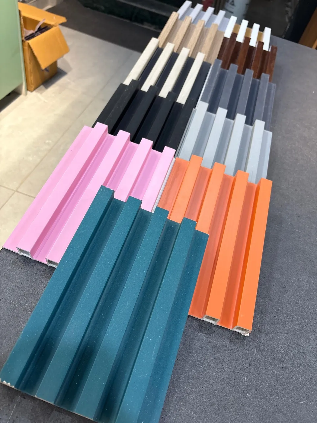 Fluted louver samples fanned out in wood tones, white, grey, black, pink, orange and teal