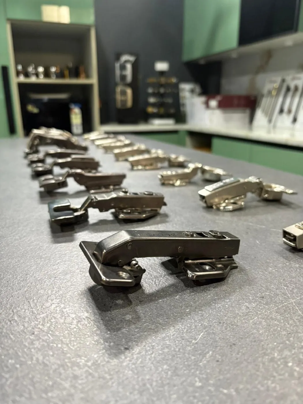 Concealed soft close hinges laid out, with one hinge in sharp focus