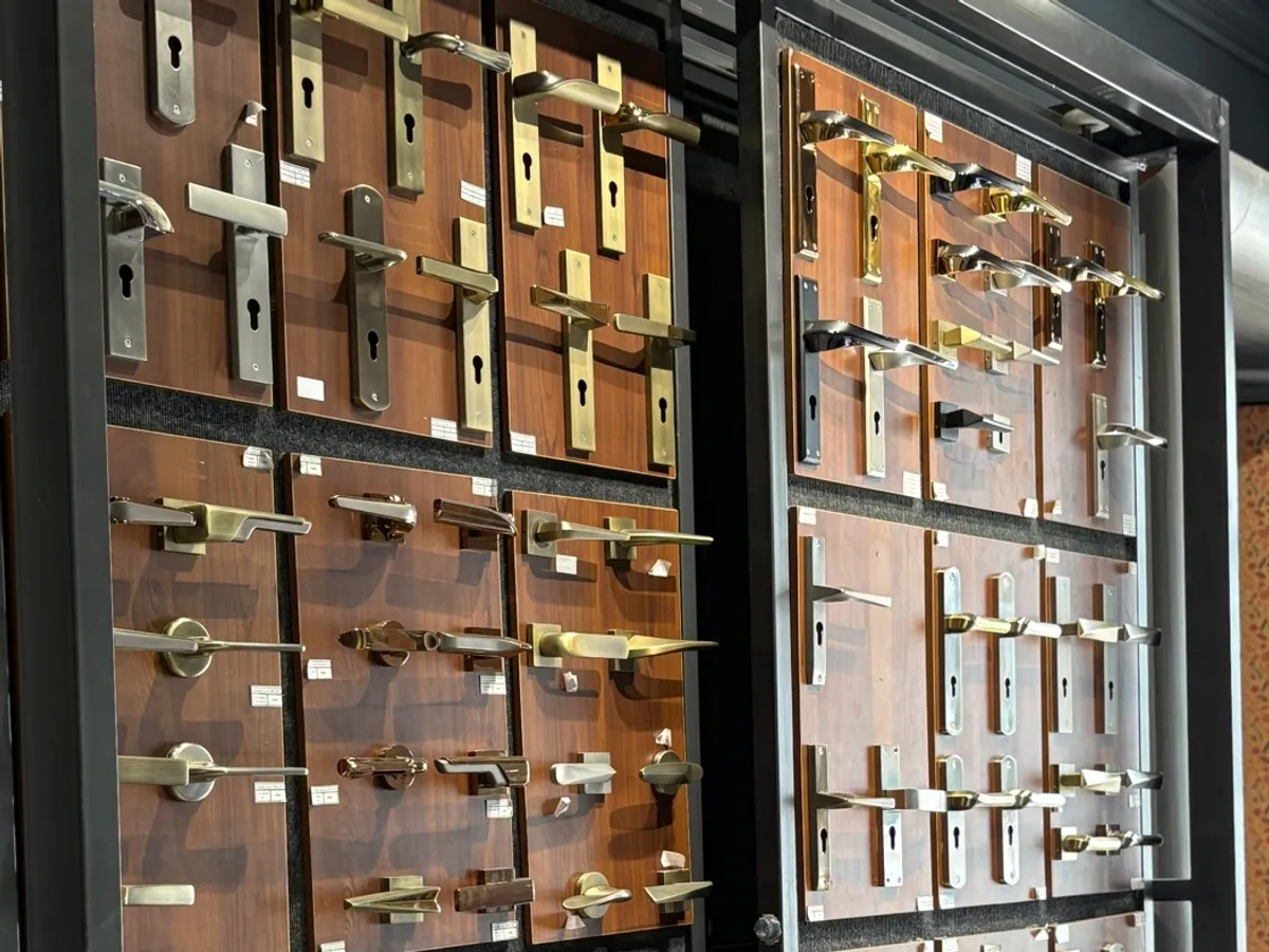 Showroom display wall of cabinet door handles and locks mounted on wooden panels