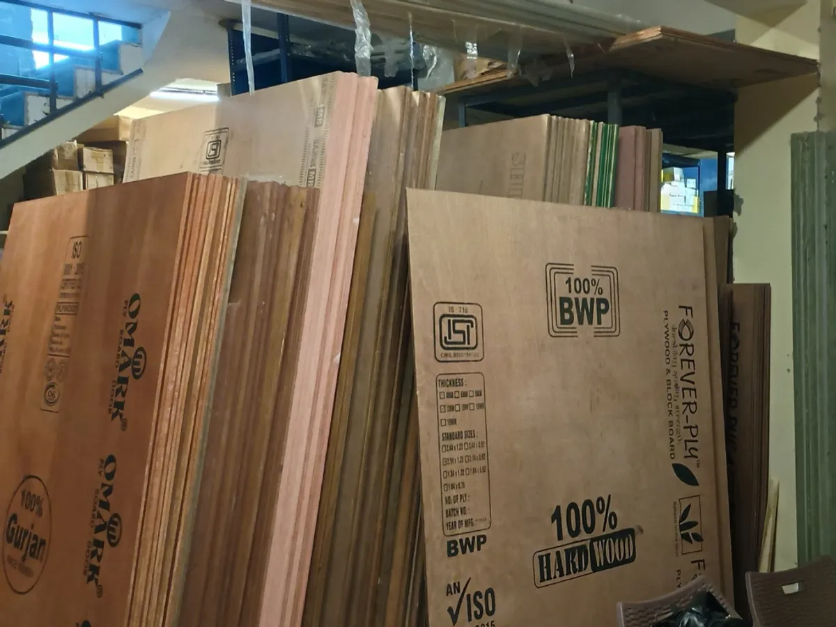 Stacked plywood sheets stamped 100% BWP and ISI in a warehouse