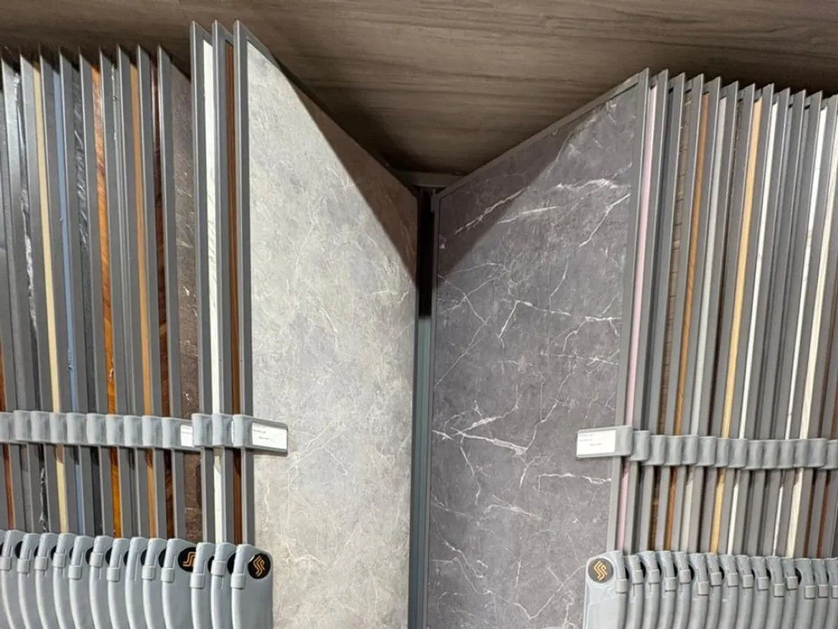 A showroom rack of large marble- and wood-look panel and laminate sheets